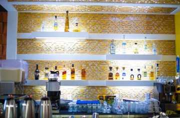 Detalle de barra de bar en madera con botellas en La Penitencia Restaurante